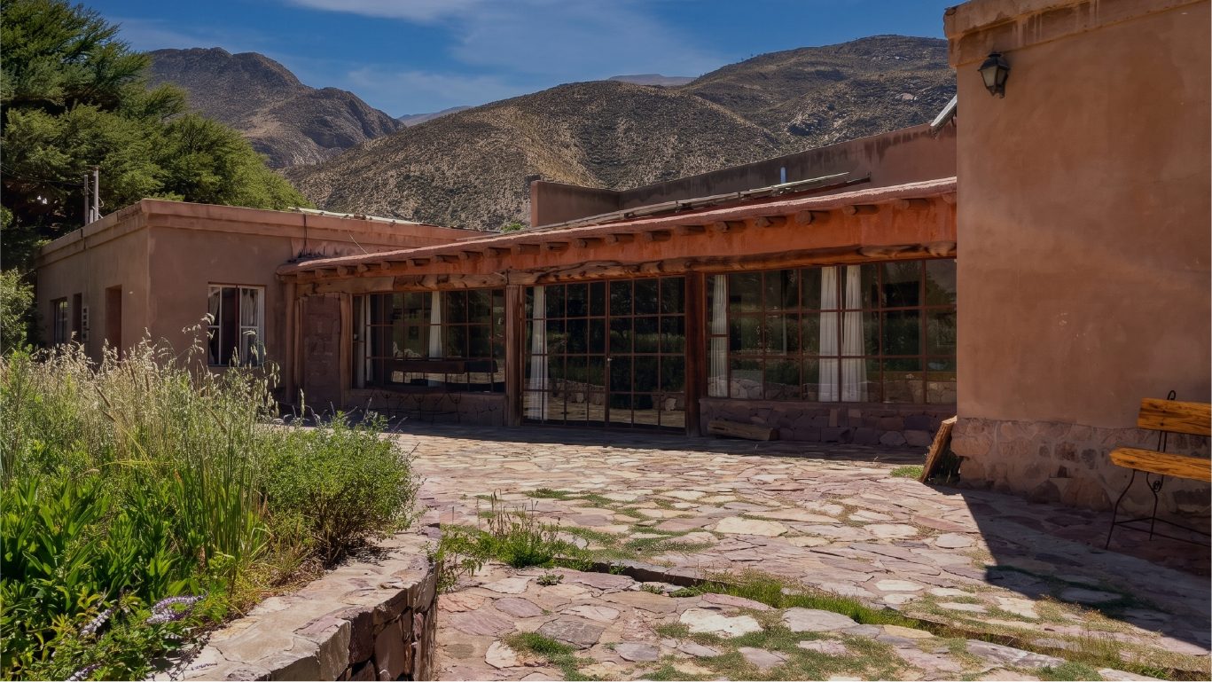 Frente de la hostería de adobe con los cerros detrás